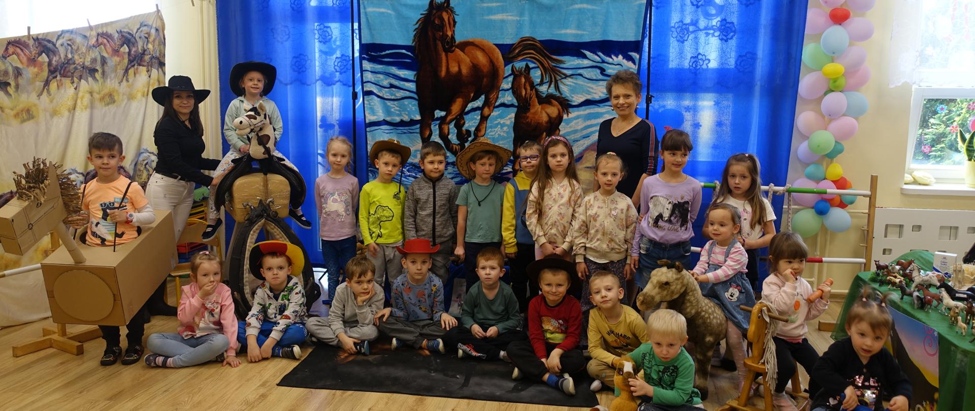 Zdjęcie grupowe przedszkolaków na tle dekoracji. 