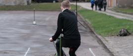 Uczeń na rowerze wykonuje ćwiczenia praktyczne na wyznaczonym torze