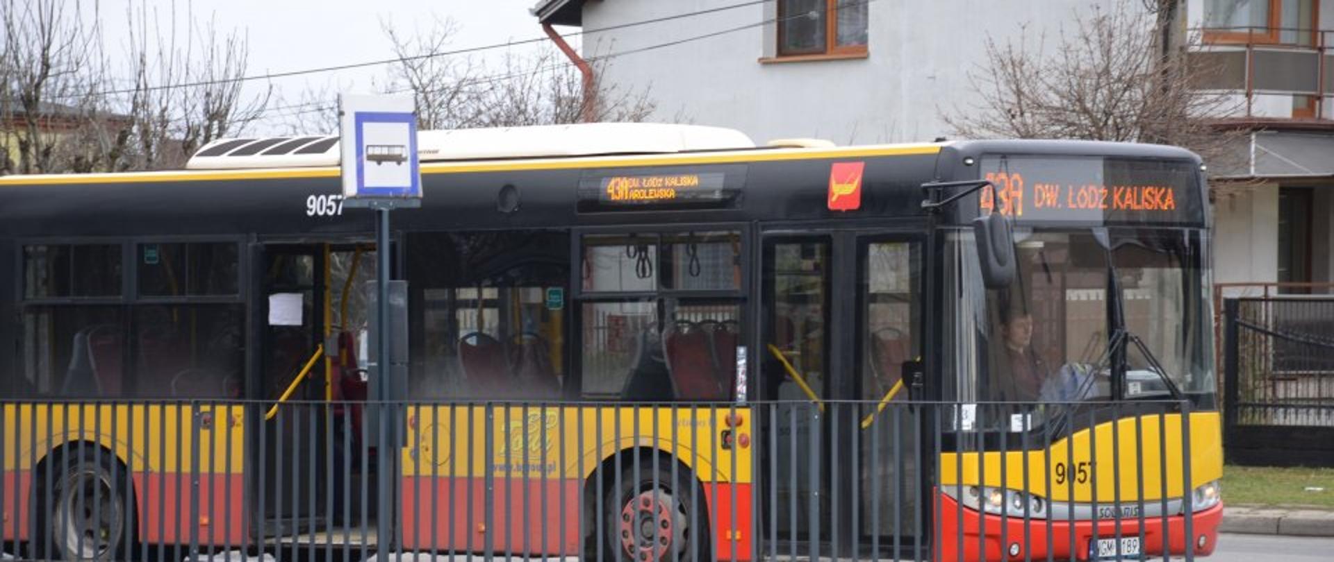 Zdjęcie przedstawia żółto-czerwony autobus linii 43A do Dw. Łódź Kaliska. Stoi on na krańcówce w Konstantynowie Łódzkim. Przed nim są grafitowe barierki oraz znak autobusu. 