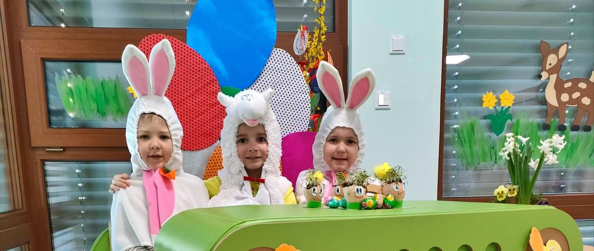 Przedszkolaki w kolorowych strojach i ozdobach świętujące Wielkanoc