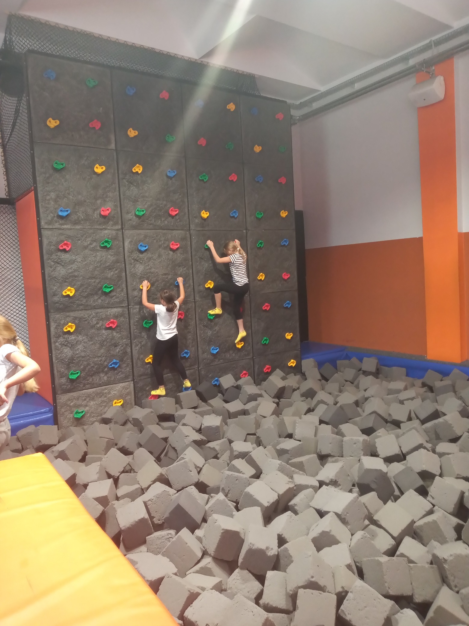 Dwie dziewczynki wspinają się na ściance wspinaczkowej
