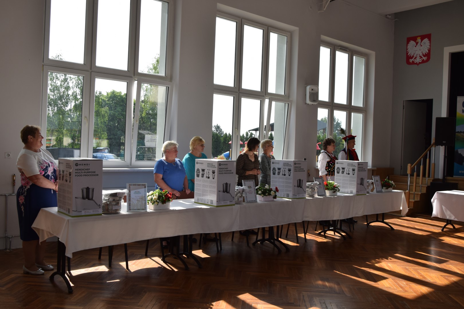 zdjęcie przedstawia przedstawicieli KGW za stołem obok przekazanych sprzętów, od prawej: KGW Miechowice Małe, KGW Miechowice Wielkie, KGW Sikorzyce, KGW Jadowniki Mokre