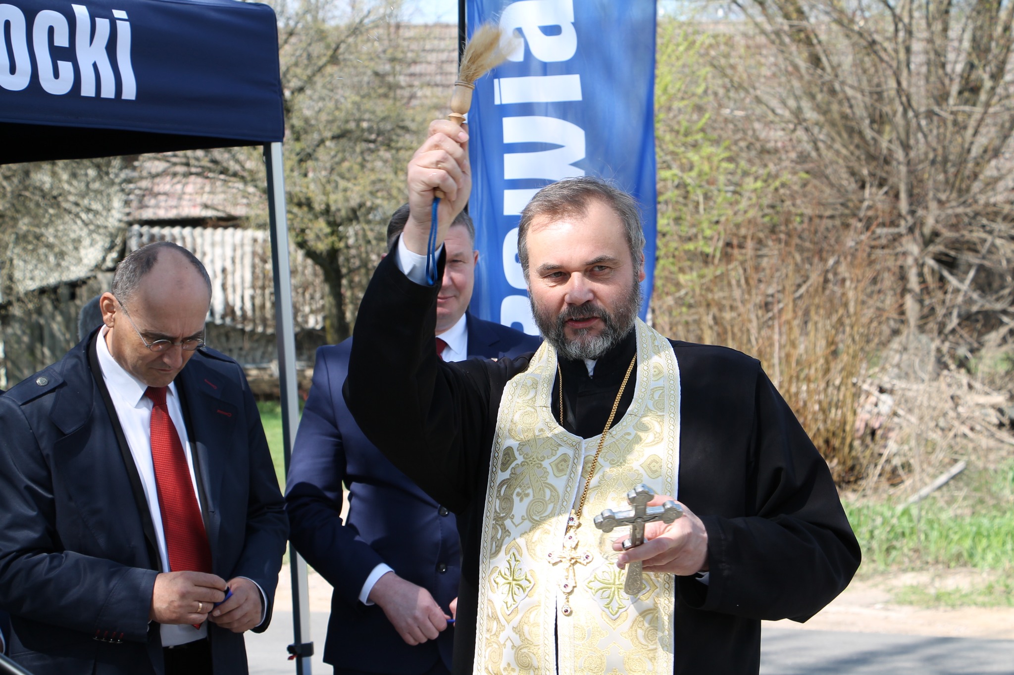 Uczestnicy oficjalnego otwarcia drogi - prawosławny duchowny święci drogę
