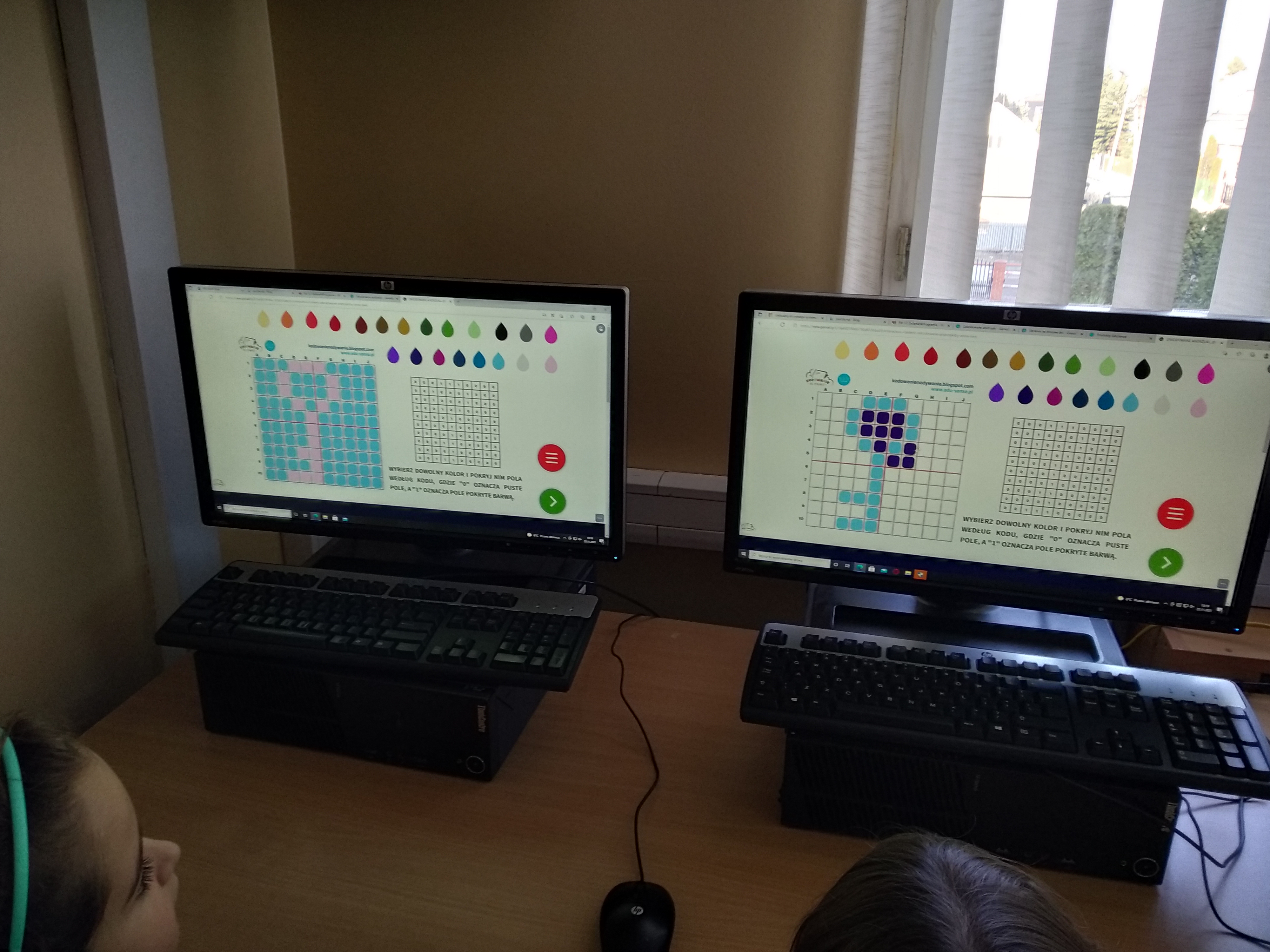 Dzieci układają na ekranach komputerów obrazu klucza z kolorowych kropek