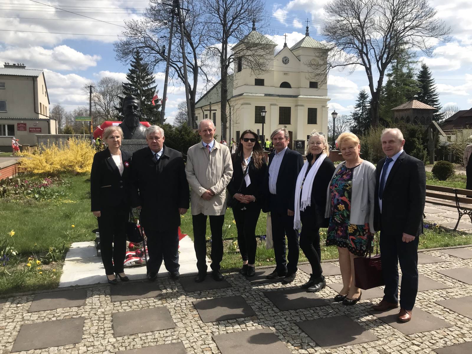 8 osób, stojących obok siebie przed pomnikiem Stanisława Pomian-Srzednickiego m.in Starosta powiatu wyszkowskiego i Wójt Gminy Brańszczyk.