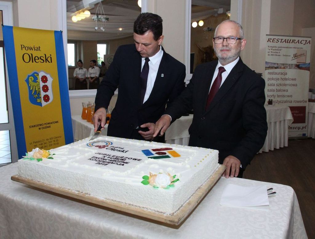 Starosta Oleski Roland Fabianek i Wicestarosta Stanisław Belka kroją tort. 