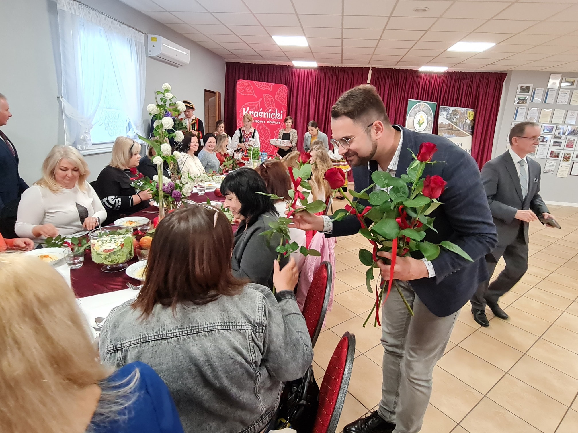 Prezes Stowarzyszenia Wschód Lubelskich Serc Pan Michał Stawiarski wręcza róże podczas Dnia Matki w Mniszku.