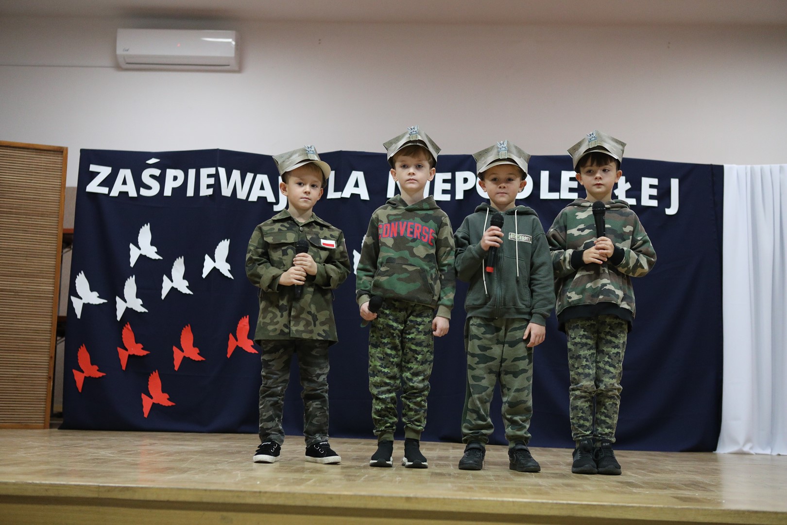 Uczestnicy konkursu podczas występu wokalnego - 4 chłopców.