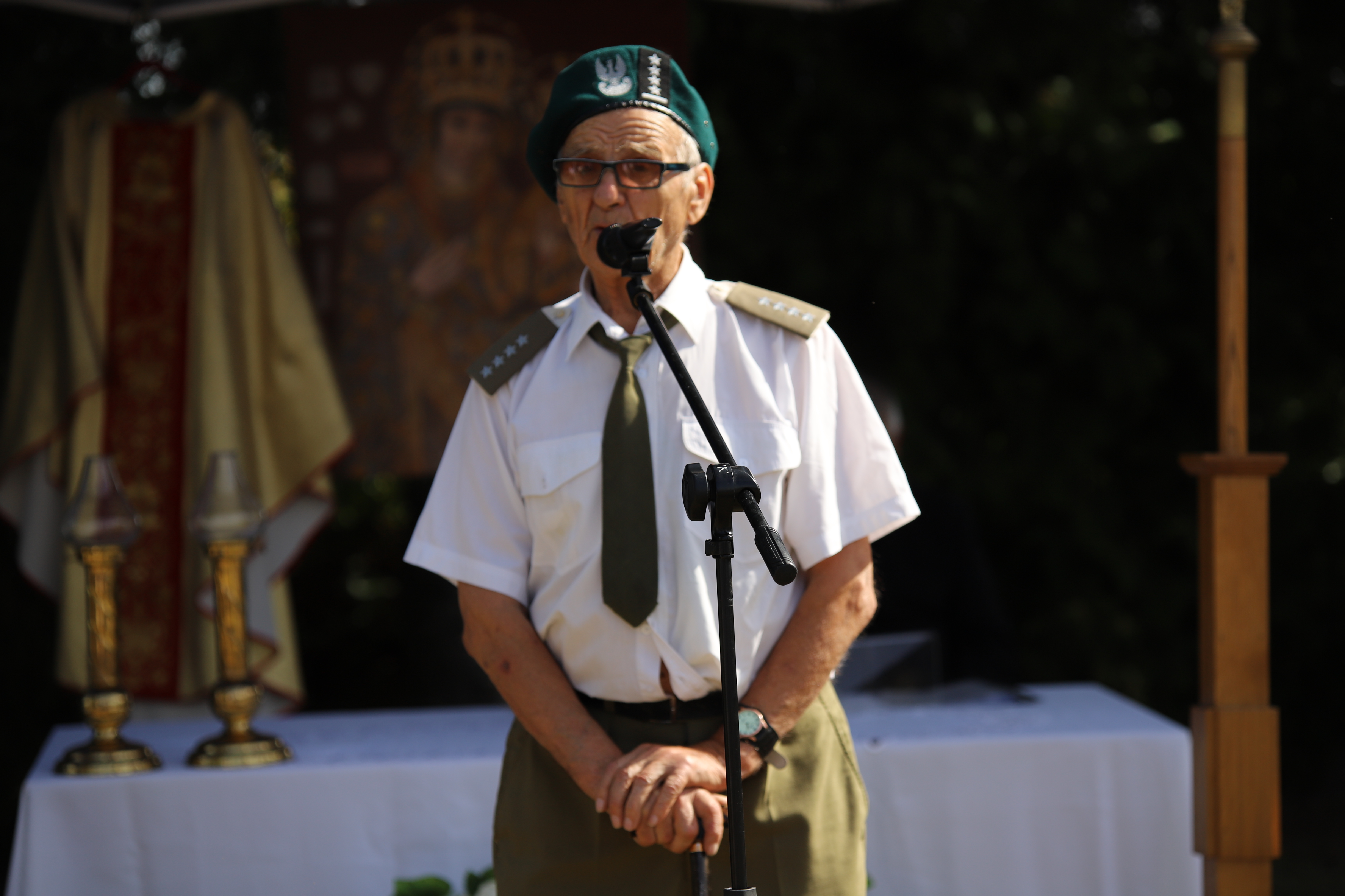 Starszy mężczyzna, kapitan żołnierz Armii Krajowej przemawia do zgromadzonych 
