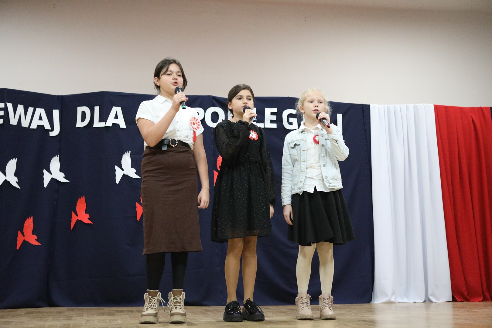 Uczestniczki konkursu podczas występu wokalnego - trzy dziewczynki.