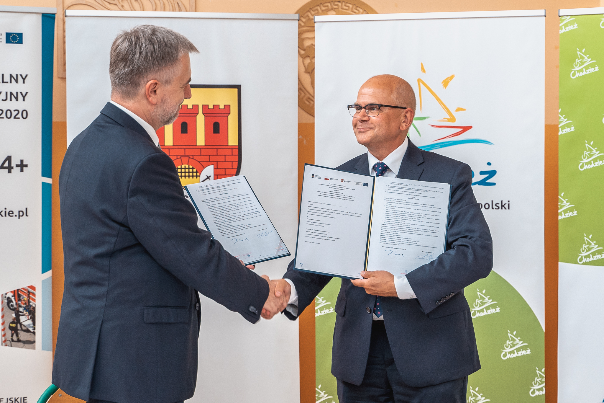Marszałek Marek Woźniak i burmistrz Jacek Gursz ściskają sobie dłonie, finalizując podpisanie umowy na projekt "mobilność miejska 2.0"