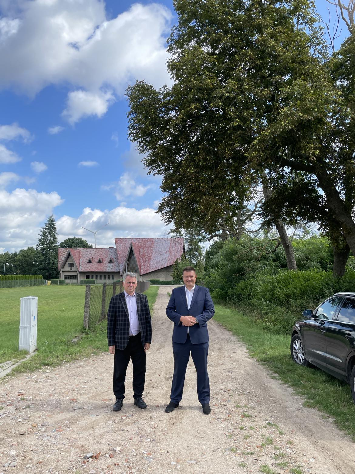 Poseł Marcin Porzucek oraz Burmistrz Janusz Piechocki stoją na drodze gruntowej prowadzącej do biblioteki w Lipinach.