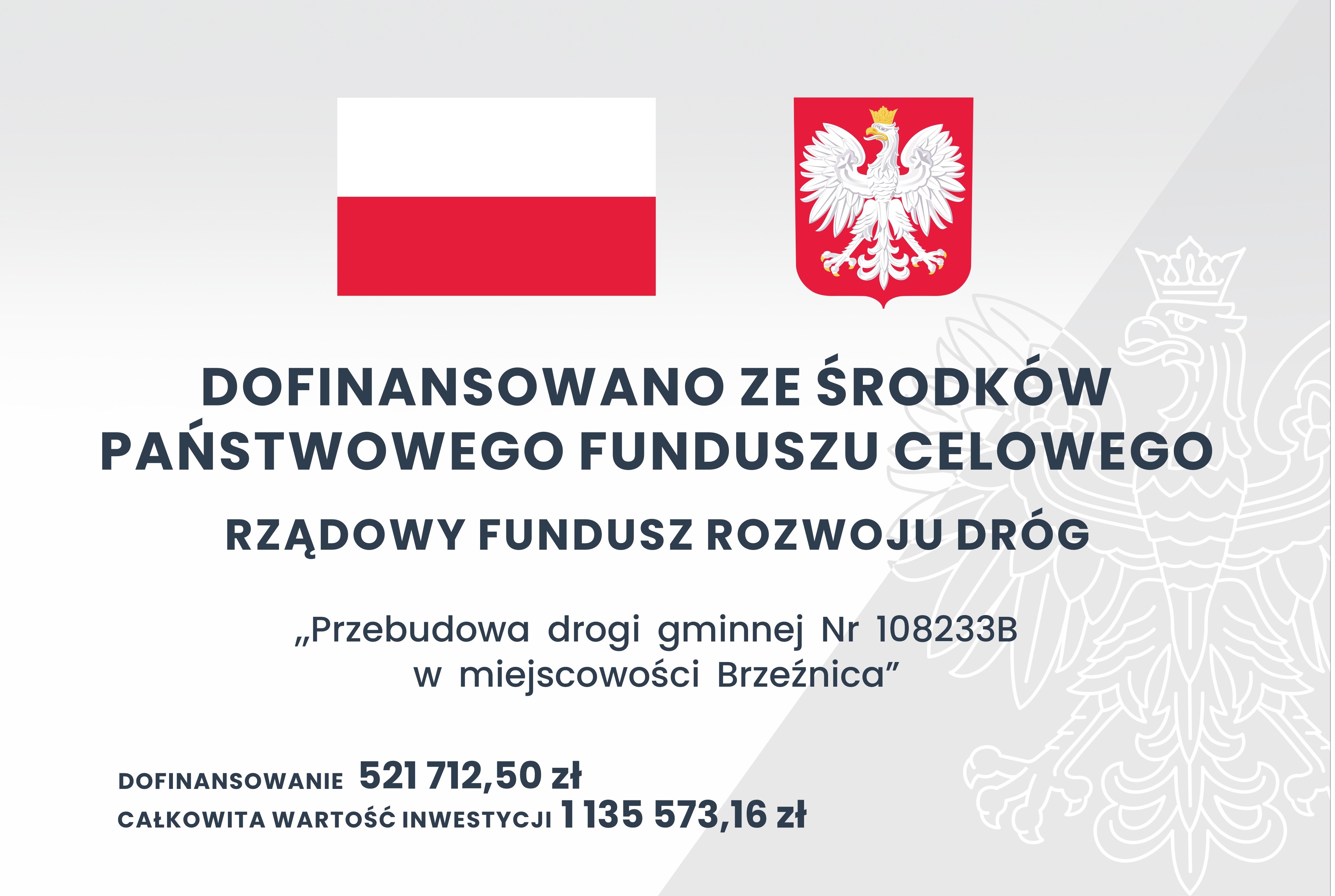 Na zdjęciu znajduję się tablica informacyjna, na której od góry umieszczona jest flaga czerwono – biała oraz godło Rzeczypospolitej Polski (orzeł biały na czerwonym tle) niżej znajduje się napis: Dofinansowano ze środków Państwowego Funduszu Celowego Rządowy Fundusz Rozwoju Dróg „Przebudowa drogi gminnej Nr 108233B w miejscowości Brzeźnica”, dofinansowanie: 521 712,50 zł całkowita wartość inwestycji 1 135 573,16 zł.