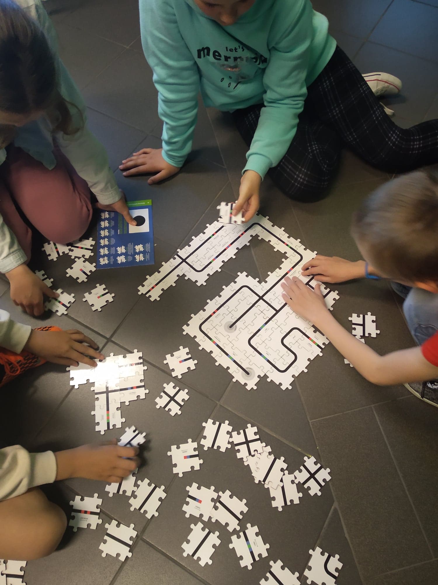 Dzieci układają puzzle z narysowanymi liniami