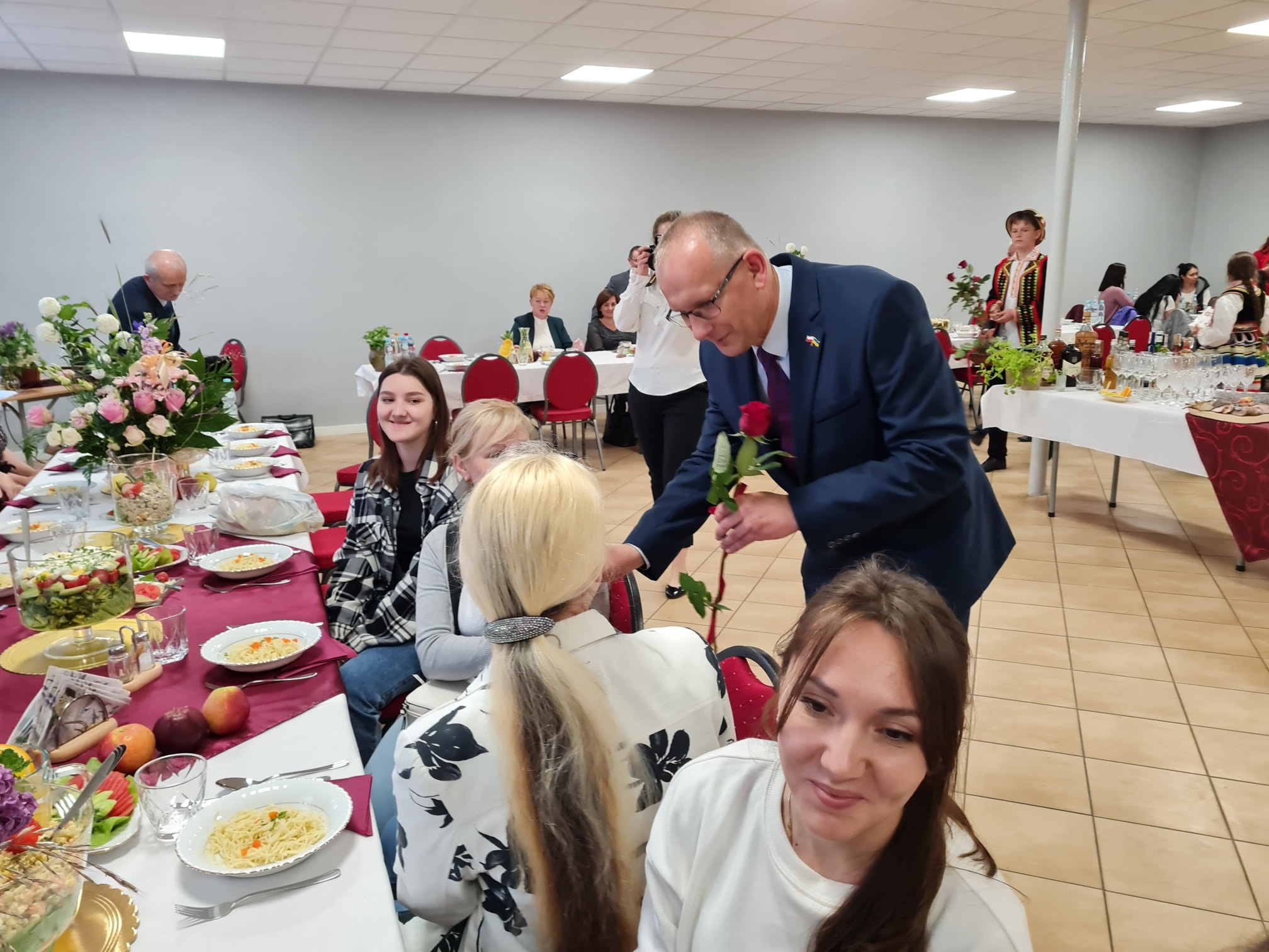 Członek Zarządu Powiatu w Kraśniku Marek Kołtun wręcza róże podczas Dnia Matki w Mniszku.