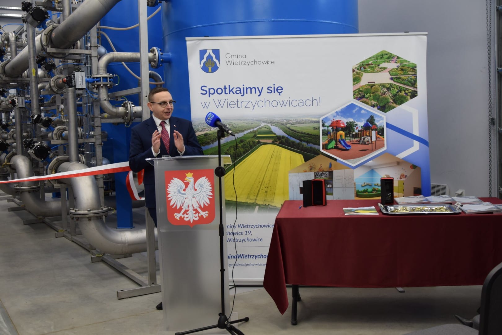 zdjęcie przedstawia Posła na Sejm RP Pana Piotra Saka w trakcie przemowy na uroczystym otwarciu nowego budynku Stacji uzdatniania Wody w Wietrzychowicach
