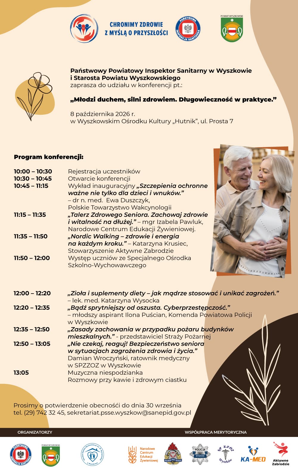 Plakat w beżowo-brązowej kolorystyce z zaproszeniem na konferencję dla seniorów „Młodzi duchem, silni zdrowiem. Długowieczność w praktyce". Wydarzenie odbędzie się 8 października 2026 r. w Wyszkowskim Ośrodku Kultury „Hutnik", ul. Prosta 7. Zaprasza Państwowy Powiatowy Inspektor Sanitarny w Wyszkowie i Starosta Powiatu Wyszkowskiego. Na plakacie widać uśmiechniętą starszą parę w czułym uścisku. Program konferencji: 10:00–10:30 – rejestracja uczestników 10:30–10:45 – otwarcie konferencji 10:45–11:15 – wykład „Szczepienia ochronne ważne nie tylko dla dzieci i wnuków" (dr n. med. Ewa Duszczyk, Polskie Towarzystwo Wakcynologii) 11:15–11:35 – „Talerz Zdrowego Seniora. Zachowaj zdrowie i witalność na dłużej" (mgr Izabela Pawluk, Narodowe Centrum Edukacji Żywieniowej) 11:35–11:50 – „Nordic Walking – zdrowie i energia na każdym kroku" (Katarzyna Krusiec, Stowarzyszenie Aktywne Zabrodzie) 11:50–12:00 – występ uczniów ze Specjalnego Ośrodka Szkolno-Wychowawczego 12:00–12:20 – „Zioła i suplementy diety – jak mądrze stosować i unikać zagrożeń" (lek. med. Katarzyna Wysocka) 12:20–12:35 – „Bądź sprytniejszy od oszusta. Cyberprzestępczość" (młodszy aspirant Ilona Puścian, Komenda Powiatowa Policji w Wyszkowie) 12:35–12:50 – „Zasady zachowania w przypadku pożaru budynków mieszkalnych" (przedstawiciel Straży Pożarnej) 12:50–13:05 – „Nie czekaj, reaguj! Bezpieczeństwo seniora w sytuacjach zagrożenia zdrowia i życia" (Damian Wroczyński, ratownik medyczny, SPZZOZ w Wyszkowie) 13:05 – muzyczna niespodzianka, rozmowy przy kawie i zdrowym ciastku Prosimy o potwierdzenie obecności do 30 września: tel. (29) 742 32 45, sekretariat.psse.wyszkow@sanepid.gov.pl. Na dole plakatu logotypy organizatorów i partnerów: Państwowa Inspekcja Sanitarna, Powiat Wyszkowski, Narodowe Centrum Edukacji Żywieniowej, Straż Pożarna, Policja, SPZZOZ Wyszków, KA-MED, Aktywne Zabrodzie.