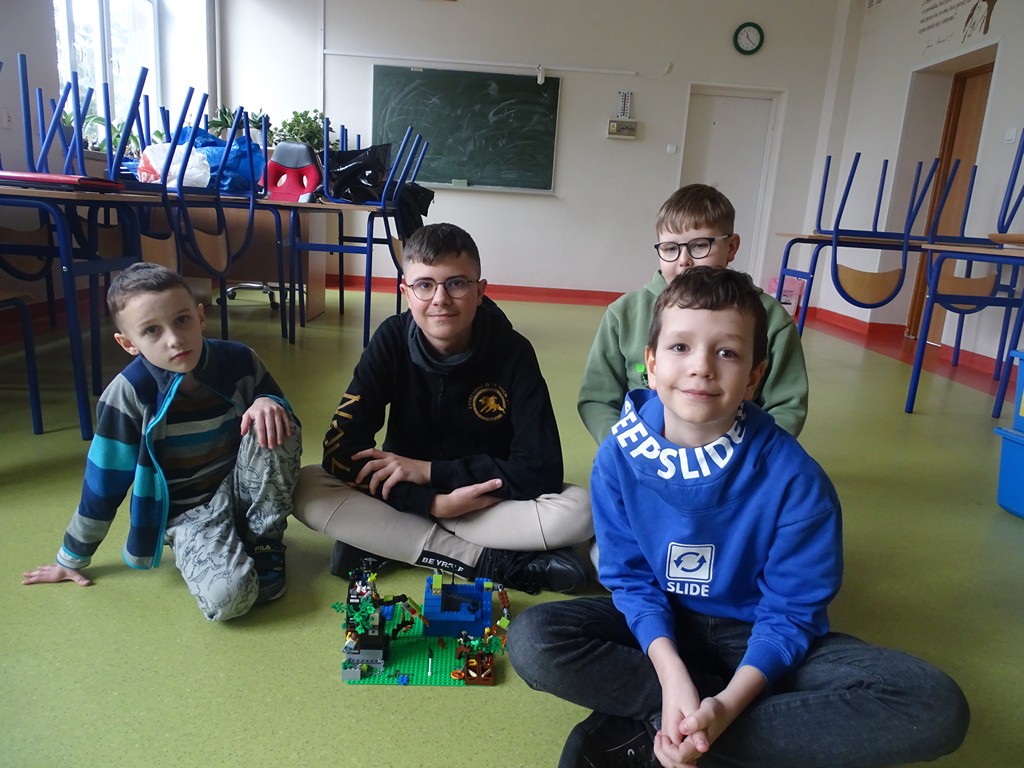Zdjęcie przedstawia jedną z grup, która prezentuję swoją budowlę z klocków LEGO. 