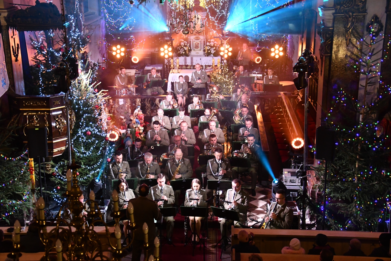 orkiestra w mundurach siedząca w kościele, w tle ołtarz