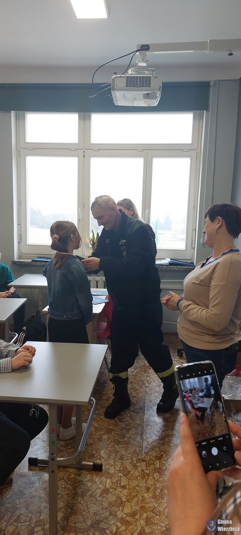 Zdjęcia przedstawiają uczestników, uczniów turnieju wiedzy pożarniczej, podczas pisania testów, oraz odbioru wyróżnień