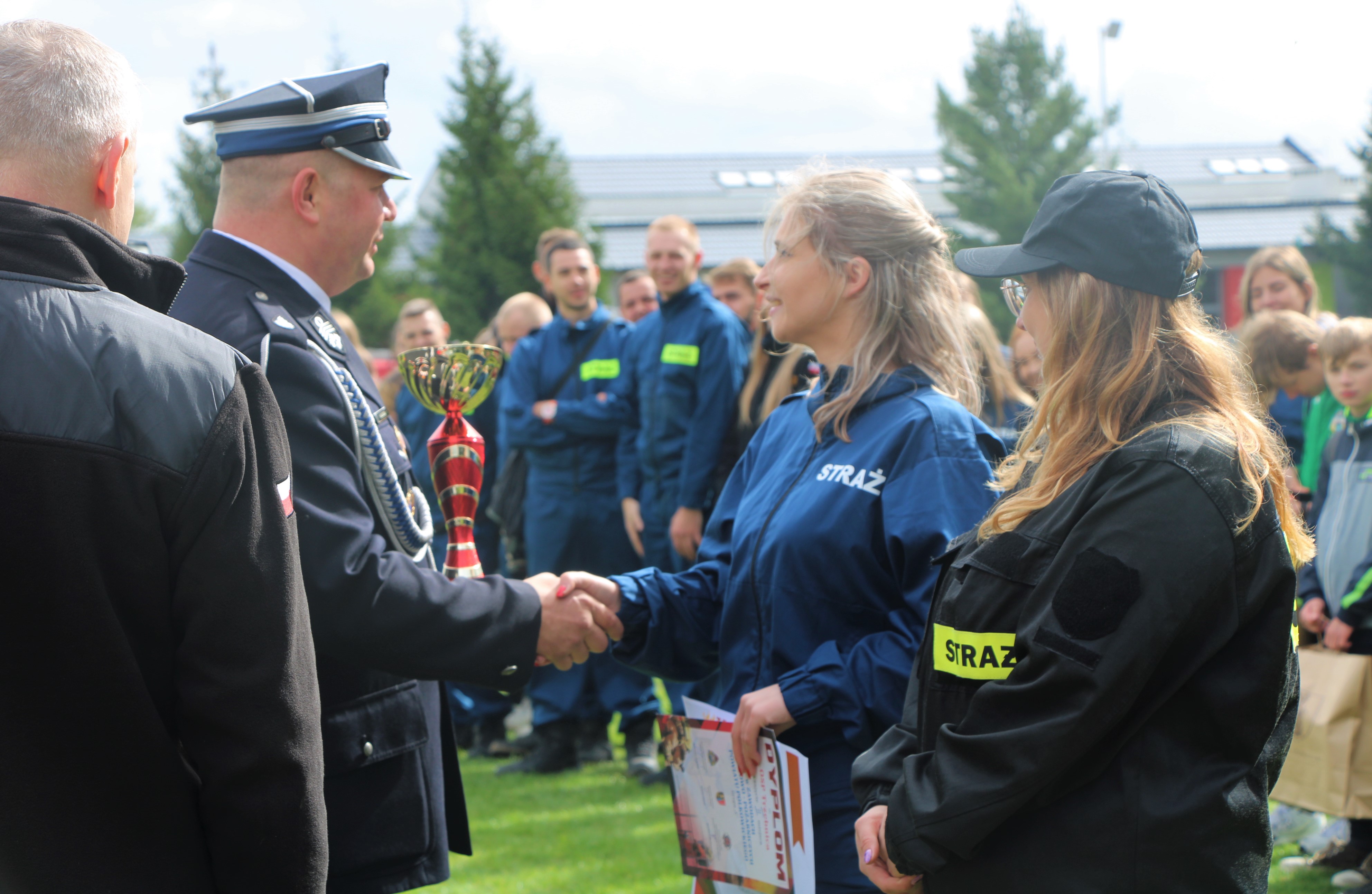 Prezes Zarządu Oddziału Powiatowego ZOSP RP w Polkowicach wręcza nagrodę za zajęcie I miejsca w zawodach strażackich 