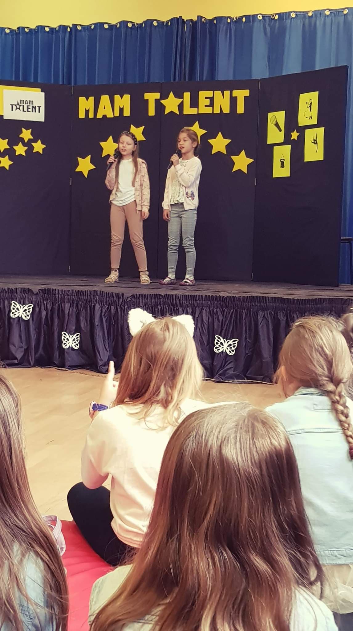 dwie dziewczynki śpiewają do mikrofonów