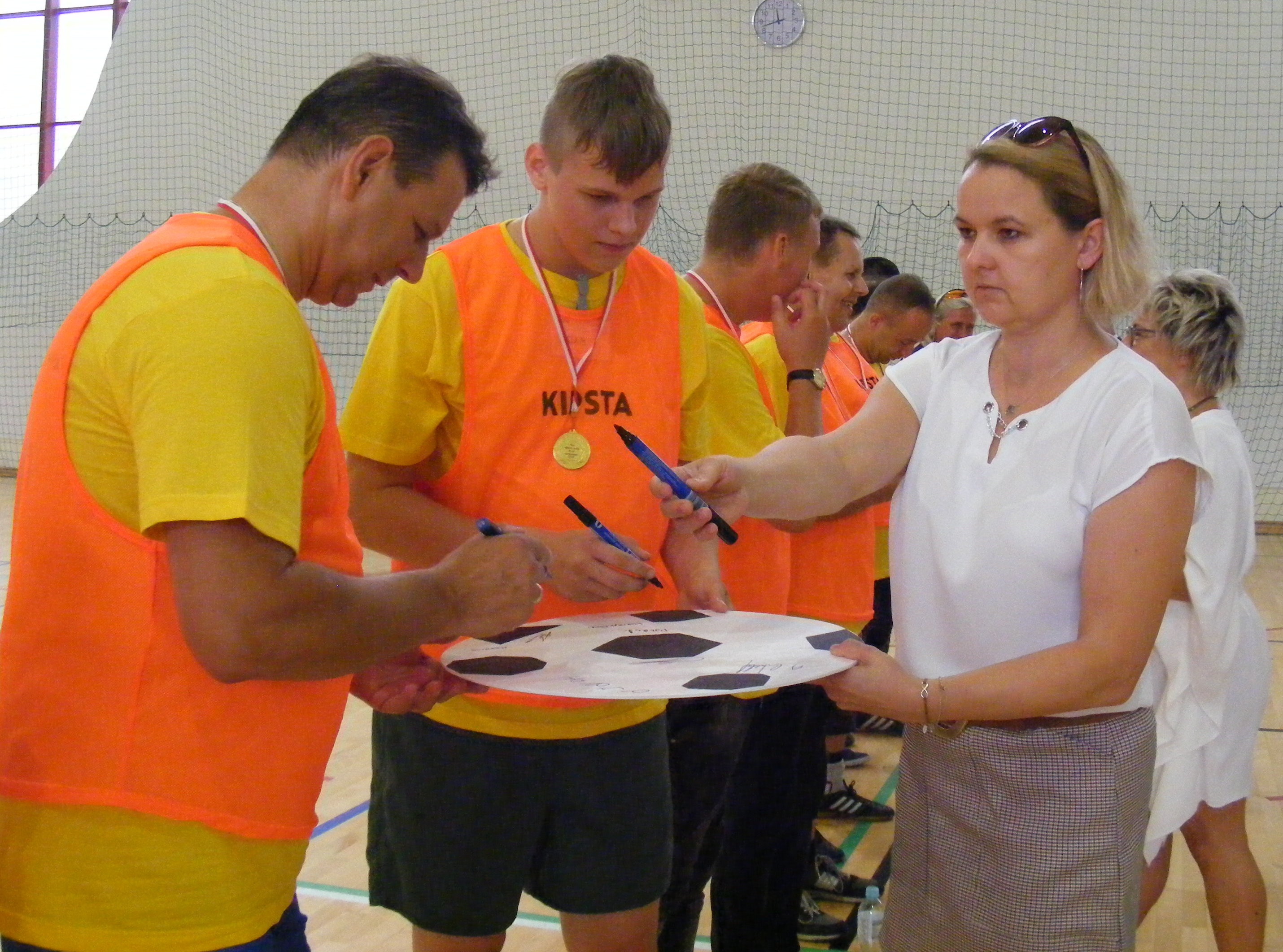 Starosta Oleski Roland Fabianek po meczu składa podpis na symbolicznej piłce nożnej. 