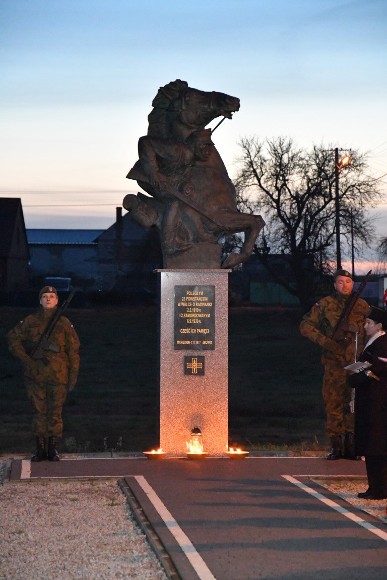pomnik i tablica w Radwankach upamiętniające Powstańców Wielkopolskich, po obu stronach pomnika stoją osoby w stroju moro