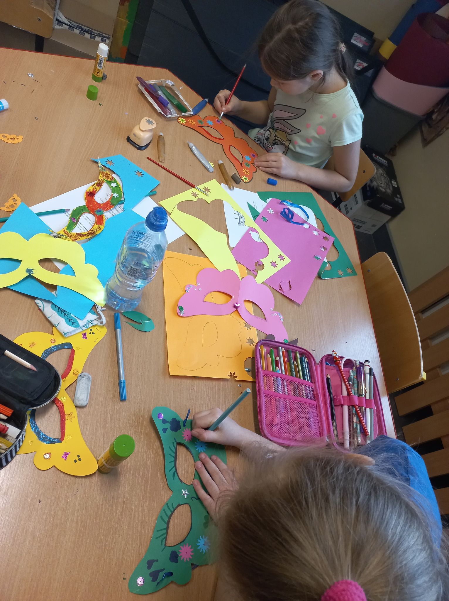 Dzieci tworzą maski karnawałowe z kolorowego papieru