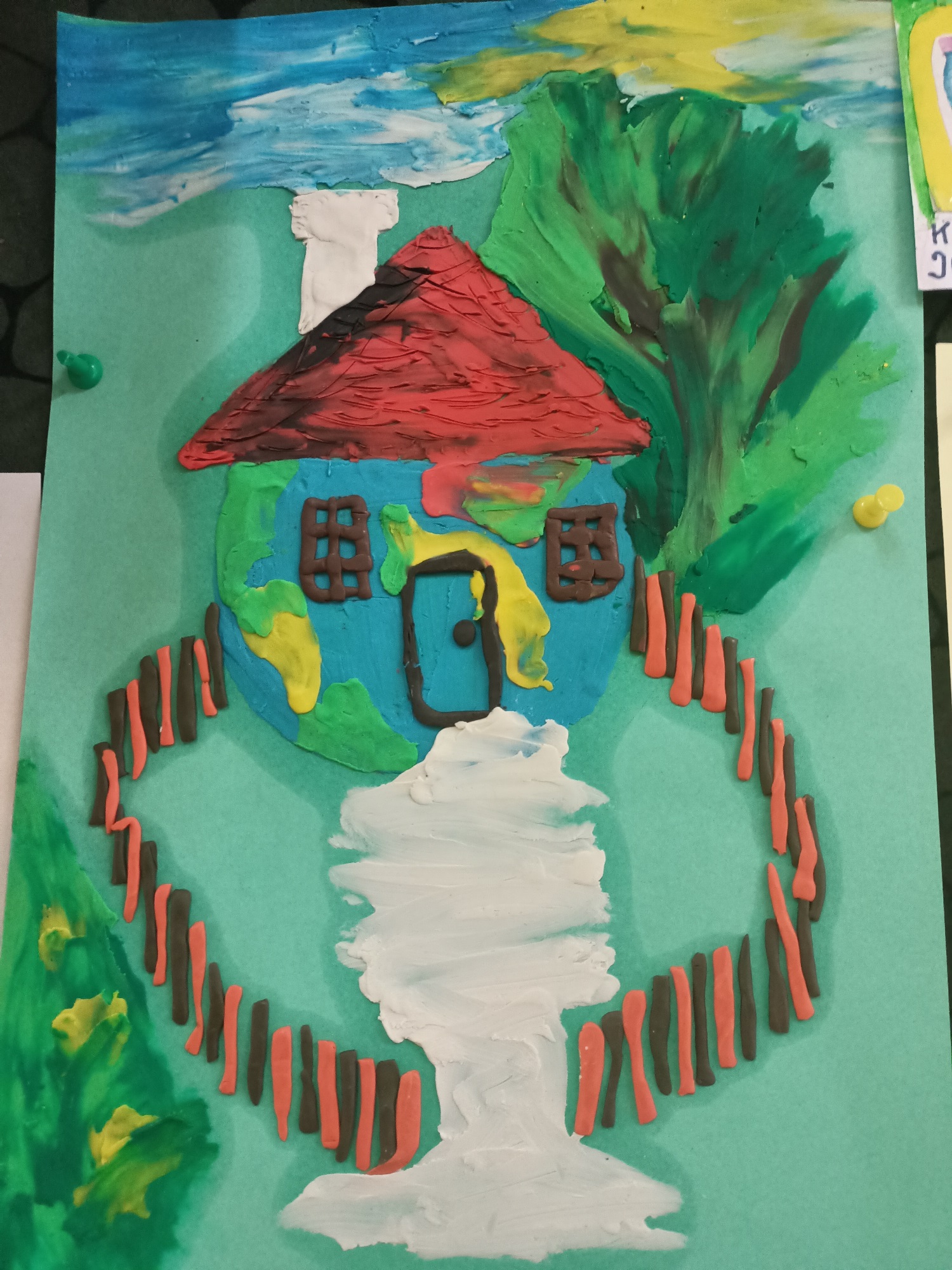 Obrazek domu w kolorach planety Ziemia z drzewem i ogrodzeniem