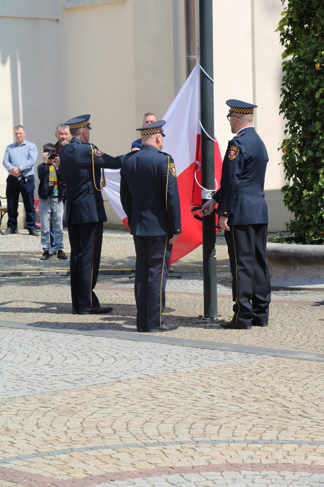 Poczet flagowy Straży Miejskiej w Polkowicach wciąga flagę narodową na maszt