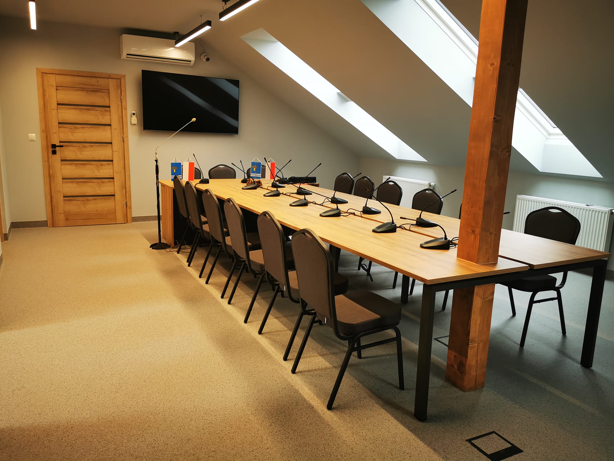 zdjęcie przedstawia duży stół oraz krzesła wokół niego w nowej sali konferencyjnej