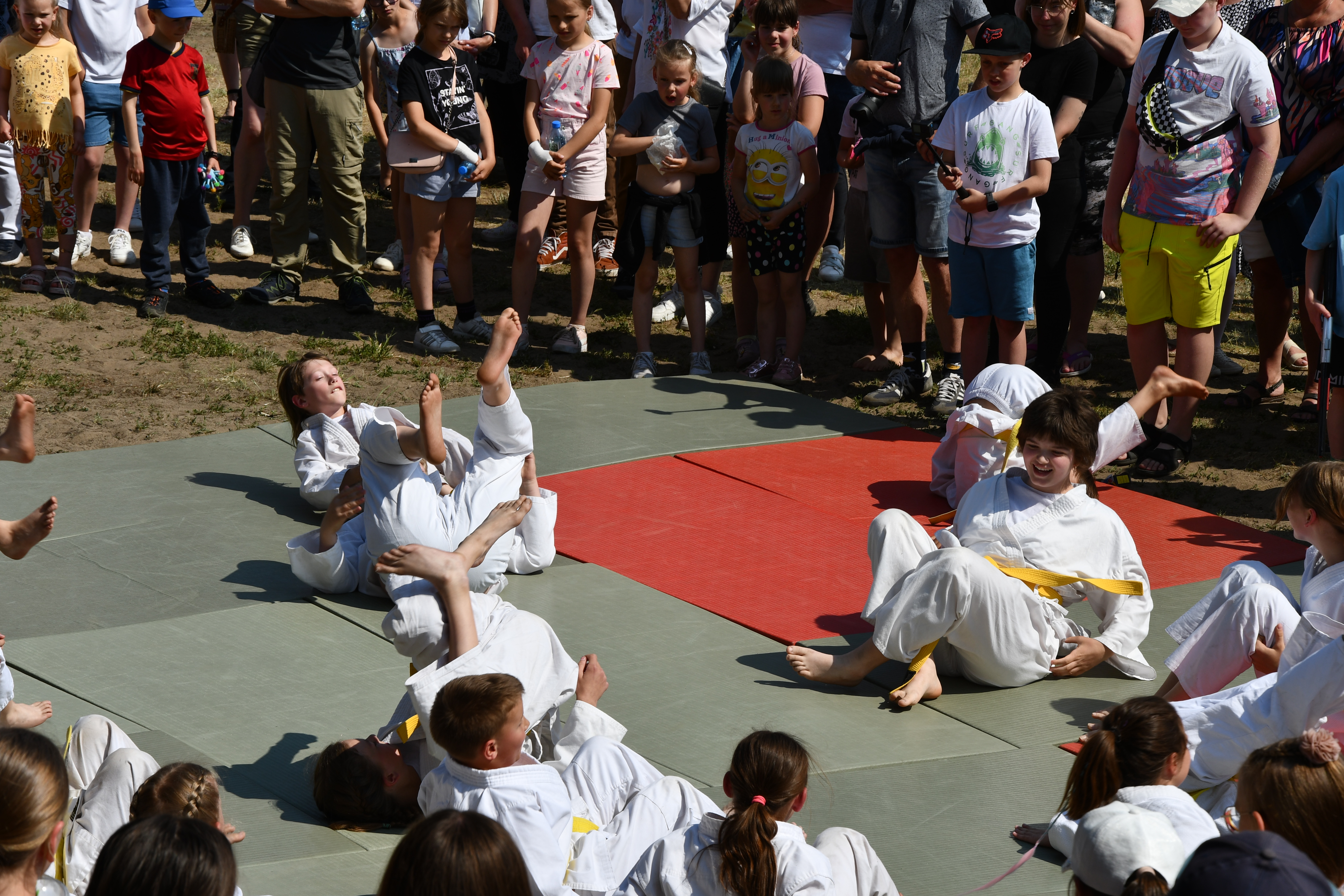 Sekcja judo pokazująca na matach rozgrzewkę poprzez rzucanie się na matę.