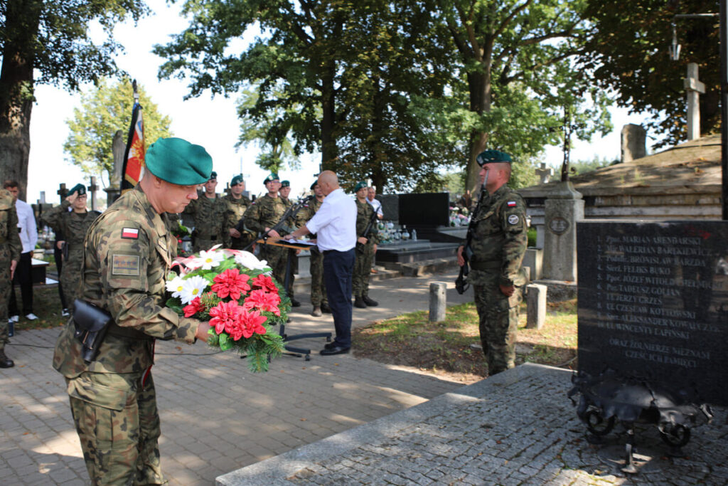 Mężczyzna, żołnierz podczas złożenia kwiatów na grobie.