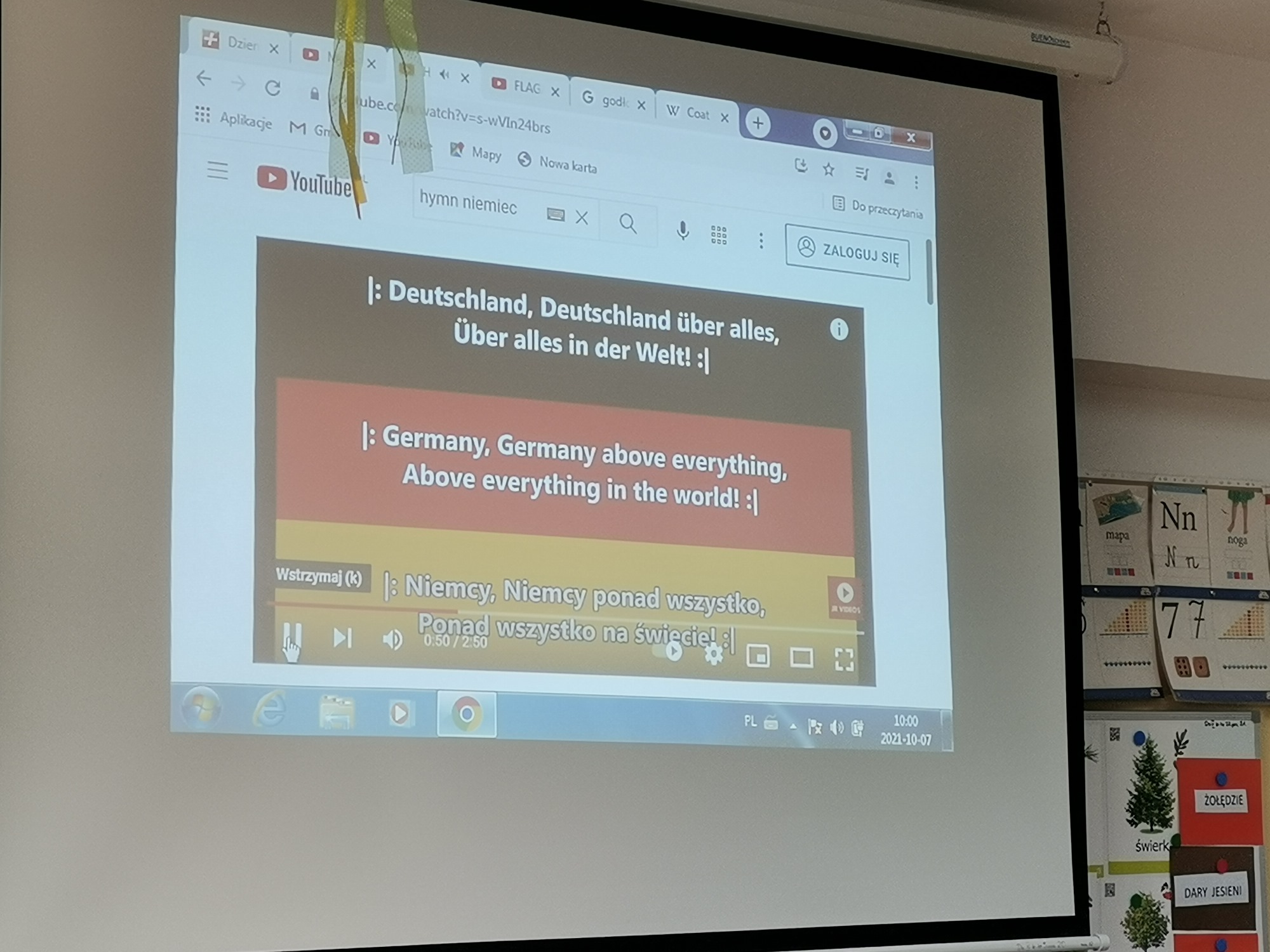 Ekran z wyświetlanym obrazem z komputera. Niemieckie napisy na tle flagi Niemiec