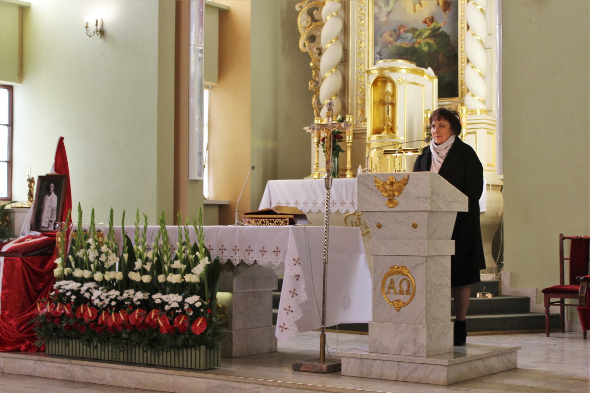 Widok na ołtarz kościoła św. Wojciecha w Skibniewie. Po prawej stronie za kamienną mównicą starosta Elżbieta Sadowska zwraca się do obecnych podczas uroczystości.