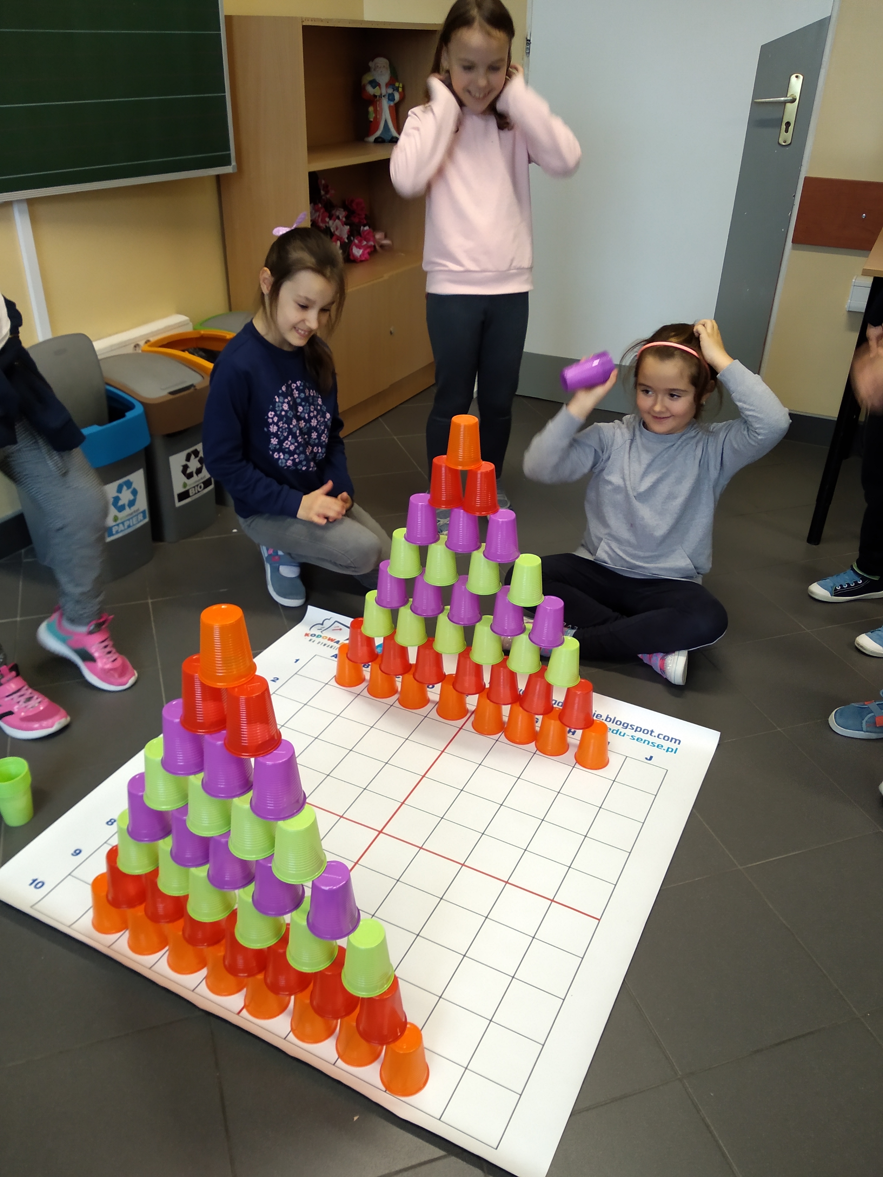 Kolorowe kubki ustawione w dwie piramidy jeden na drugim