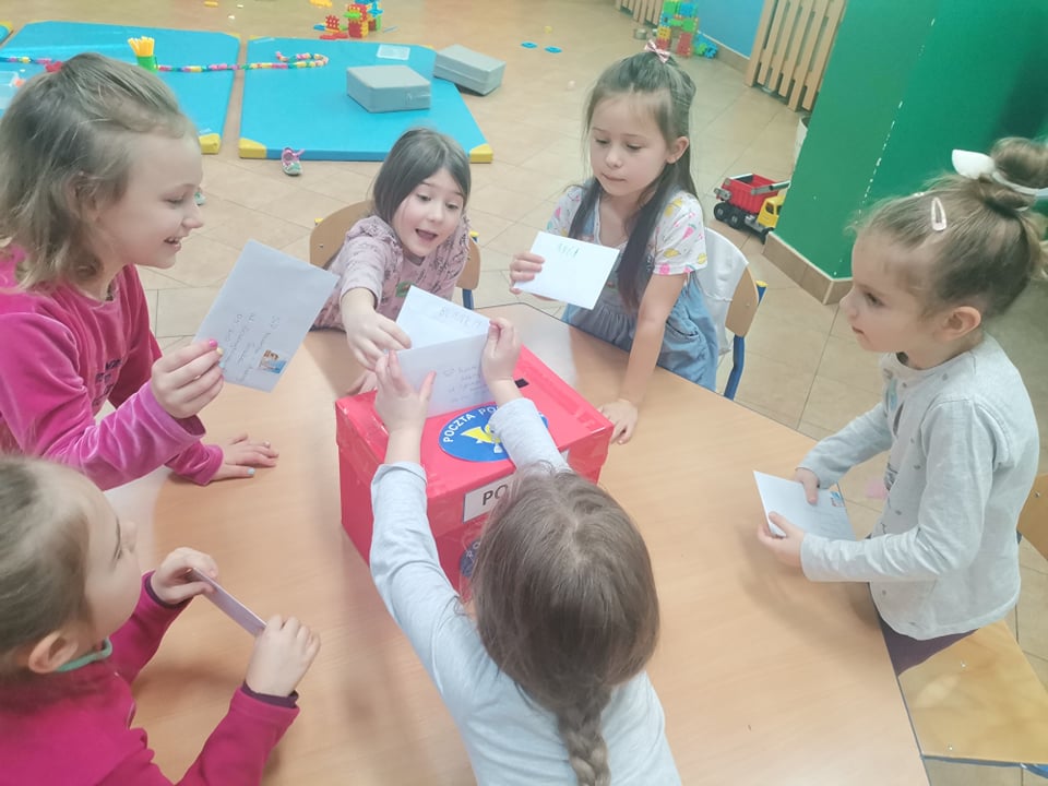 Dzieci wkładają listy do czerwonej skrzynki