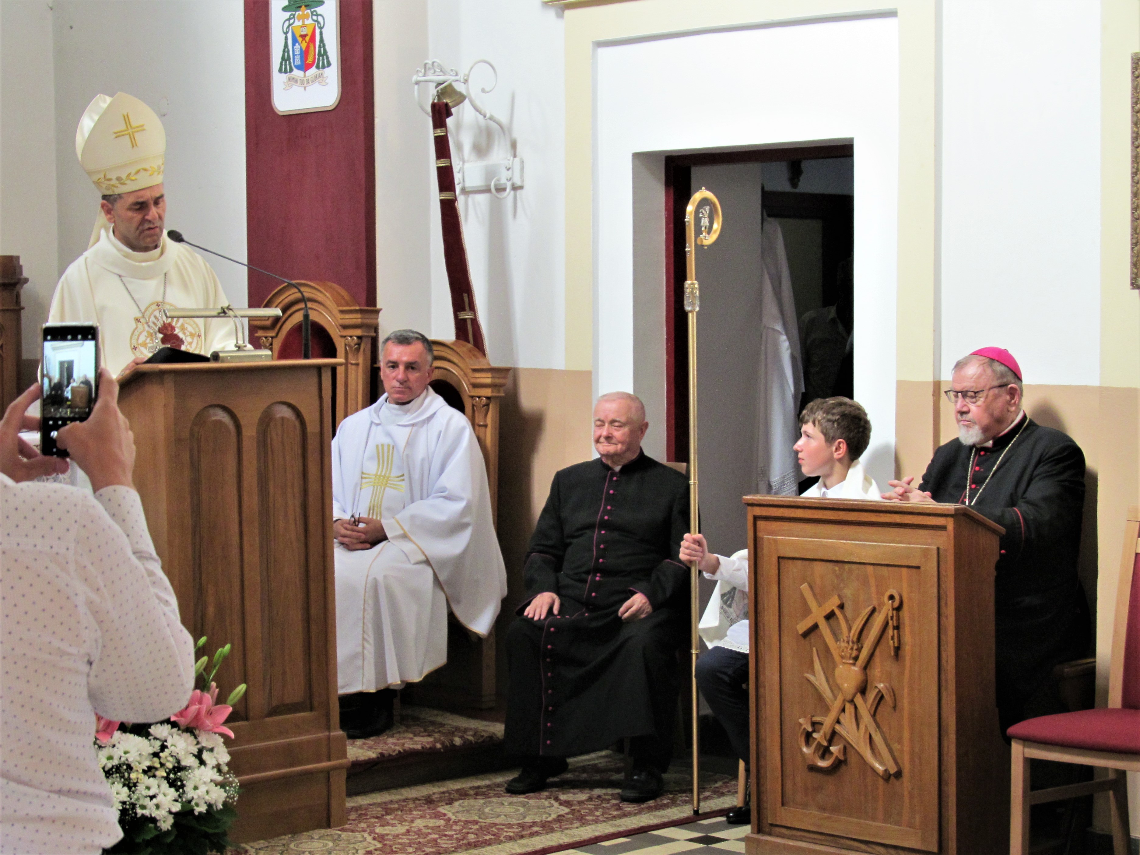 Na zdjęciu na drewnianej mównicy stojącej po lewej stronie przemawia biskup drohiczyński jego ekscelencja ks. dr Piotr Sawczuk. Na wprost widać krzesło, na którym siedzi Jubilat,. Po prawej stronie w drewnianej ławie modli się biskup senior Antoni Pacyfik Dydycz