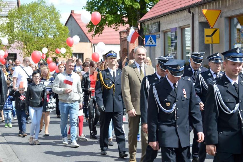 Przemarsz ulicami Budzynia, mieszkańcy z biało czerwonymi balonami, delegacja Straży Pożarnej