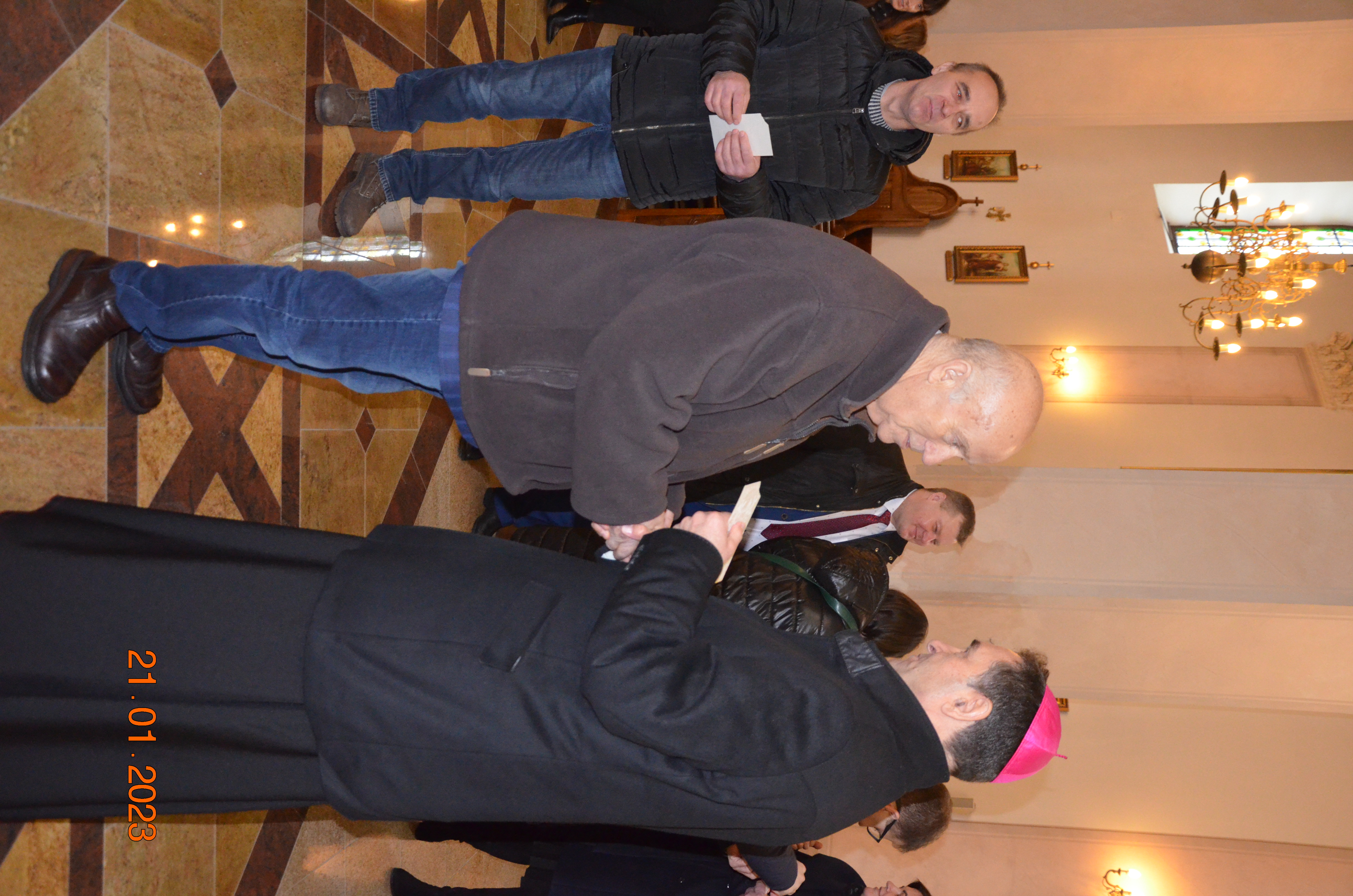 Dzielenie się opłatkiem podczas spotkania noworocznego sołtysów z Biskupem