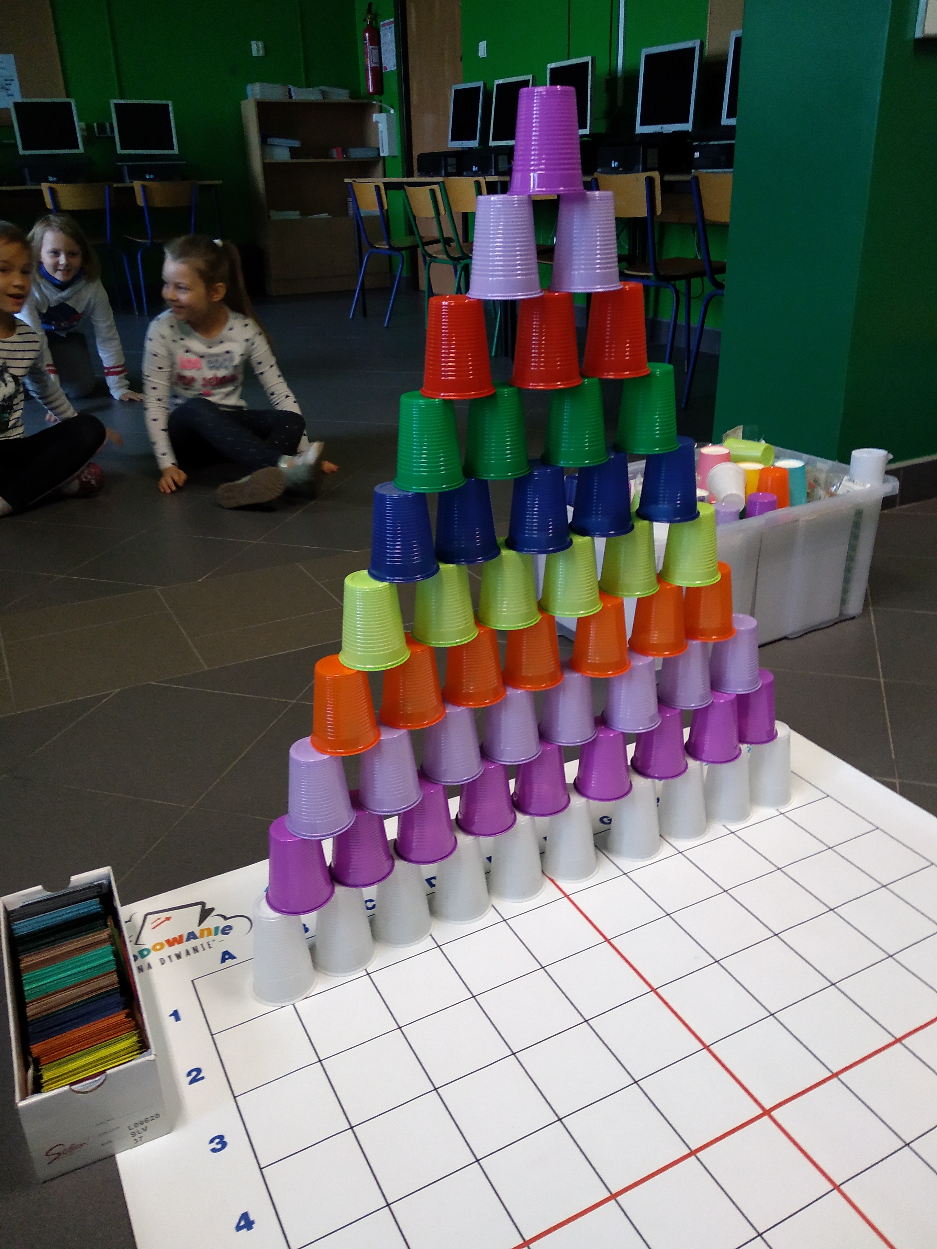 Kolorowe kubki ustawione w piramidę jeden na drugim