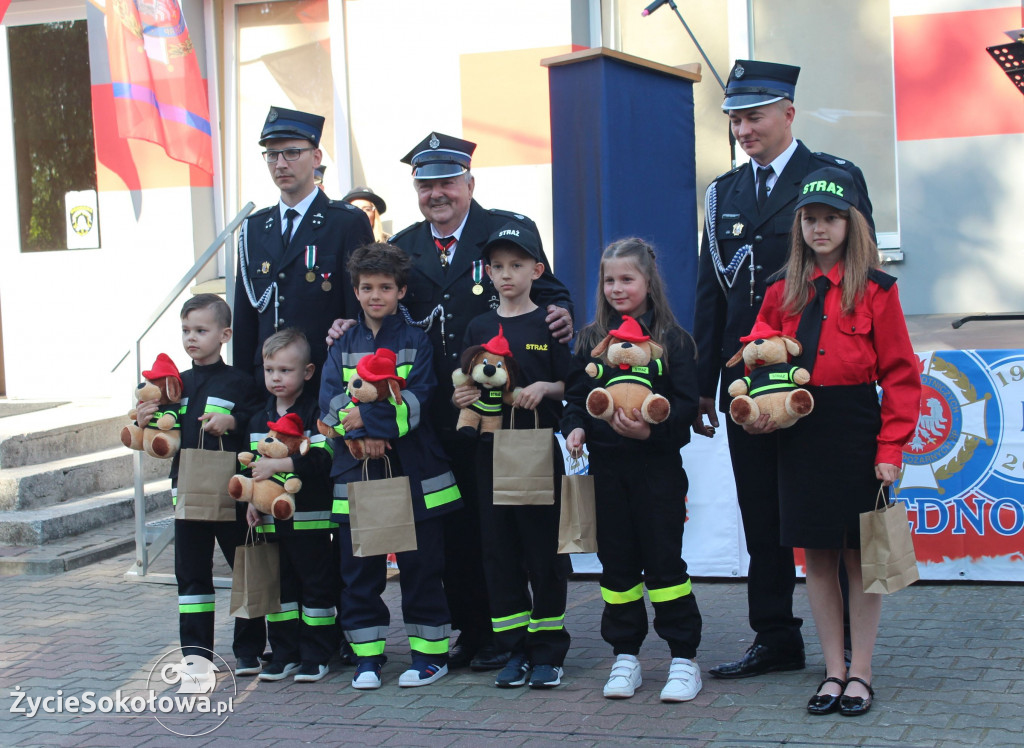 Zarząd z uhonorowanymi maskotkami najmłodszymi strażakami OSP Chruszczewka. W tle jednostka.