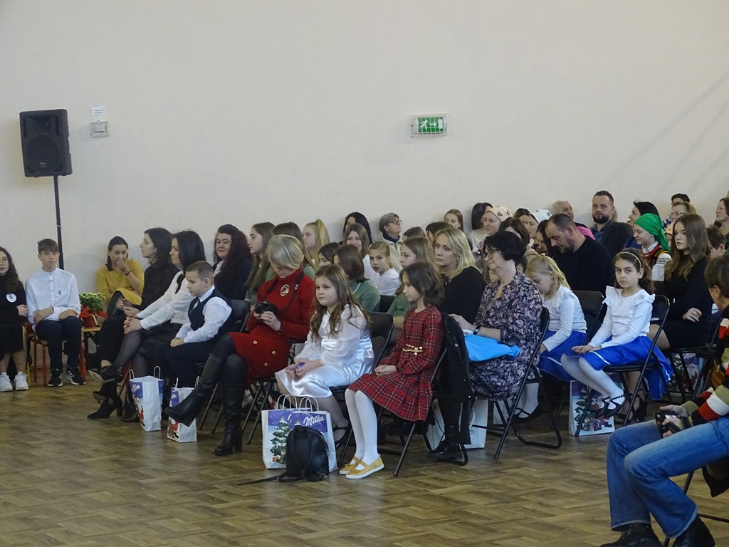 Zdjęcie przedstawia widownie oraz niektórych uczestników, którzy dumnie wysłuchują przygotowanych występów