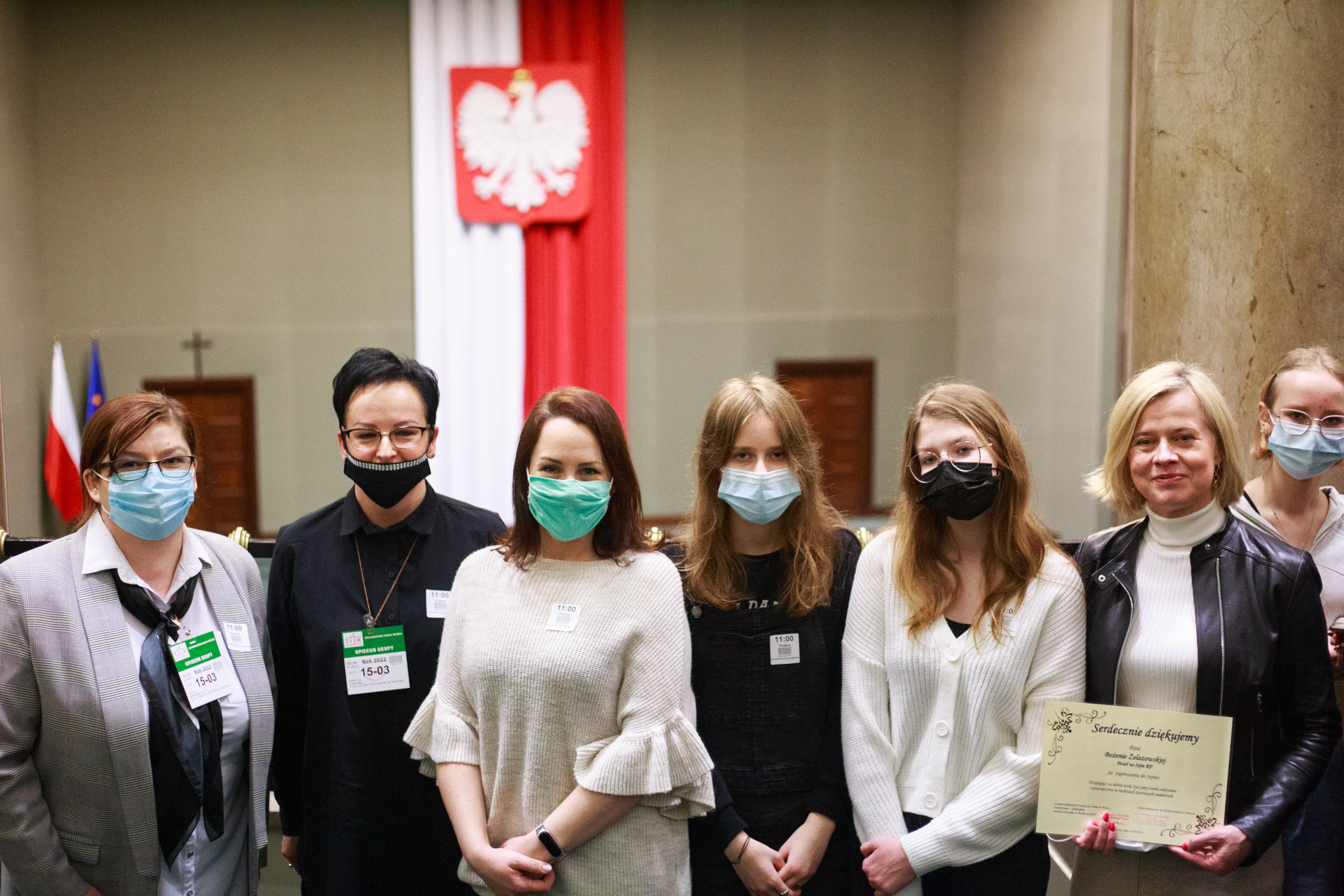 7 kobiet w maseczkach na tle godła Polski