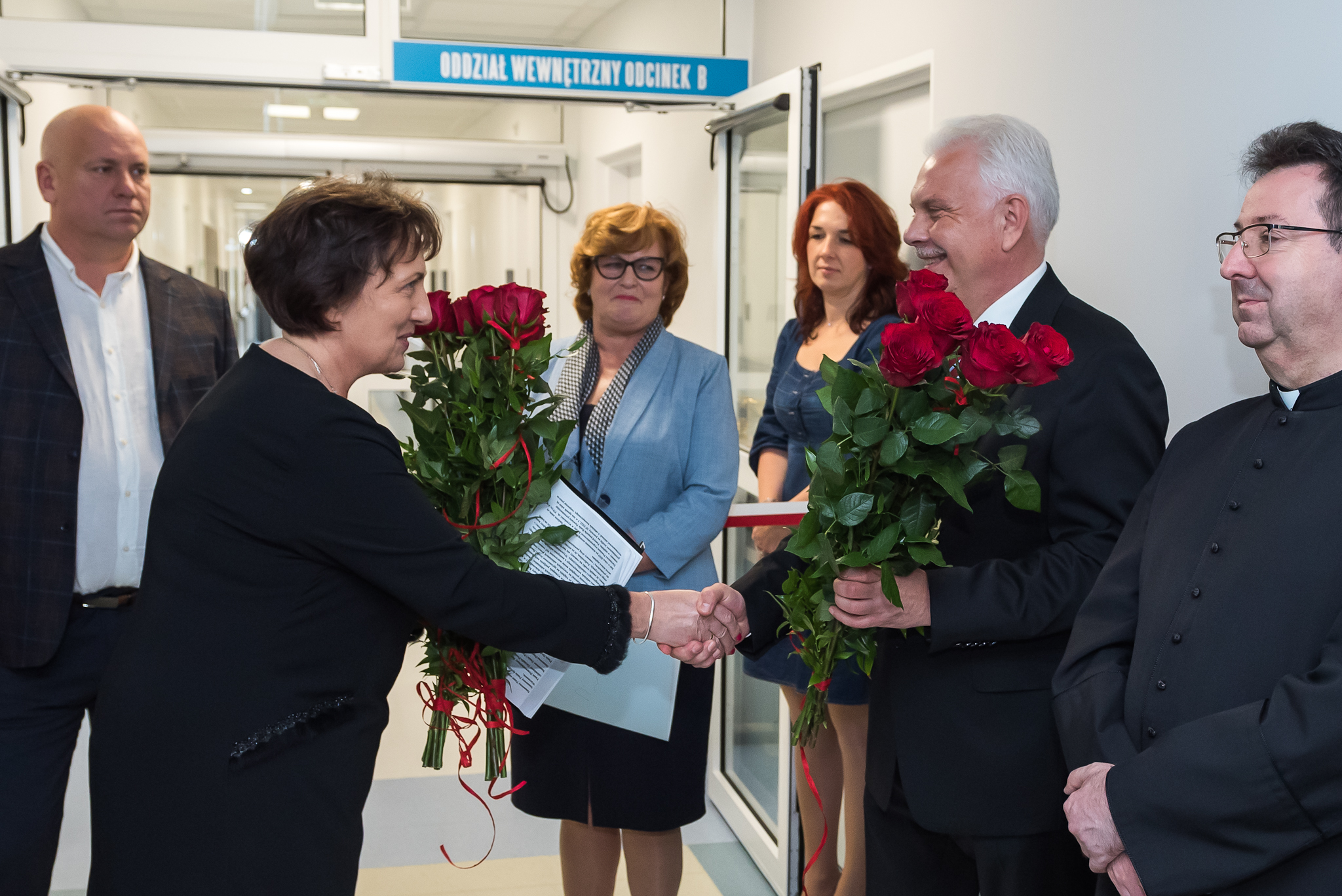 Na zdjęciu starosta Elżbieta Sadowska przed wejściem na oddział wręcza bukiet kwiatów senatorowi RP - wiceministrowi zdrowia Waldemarowi Krasce