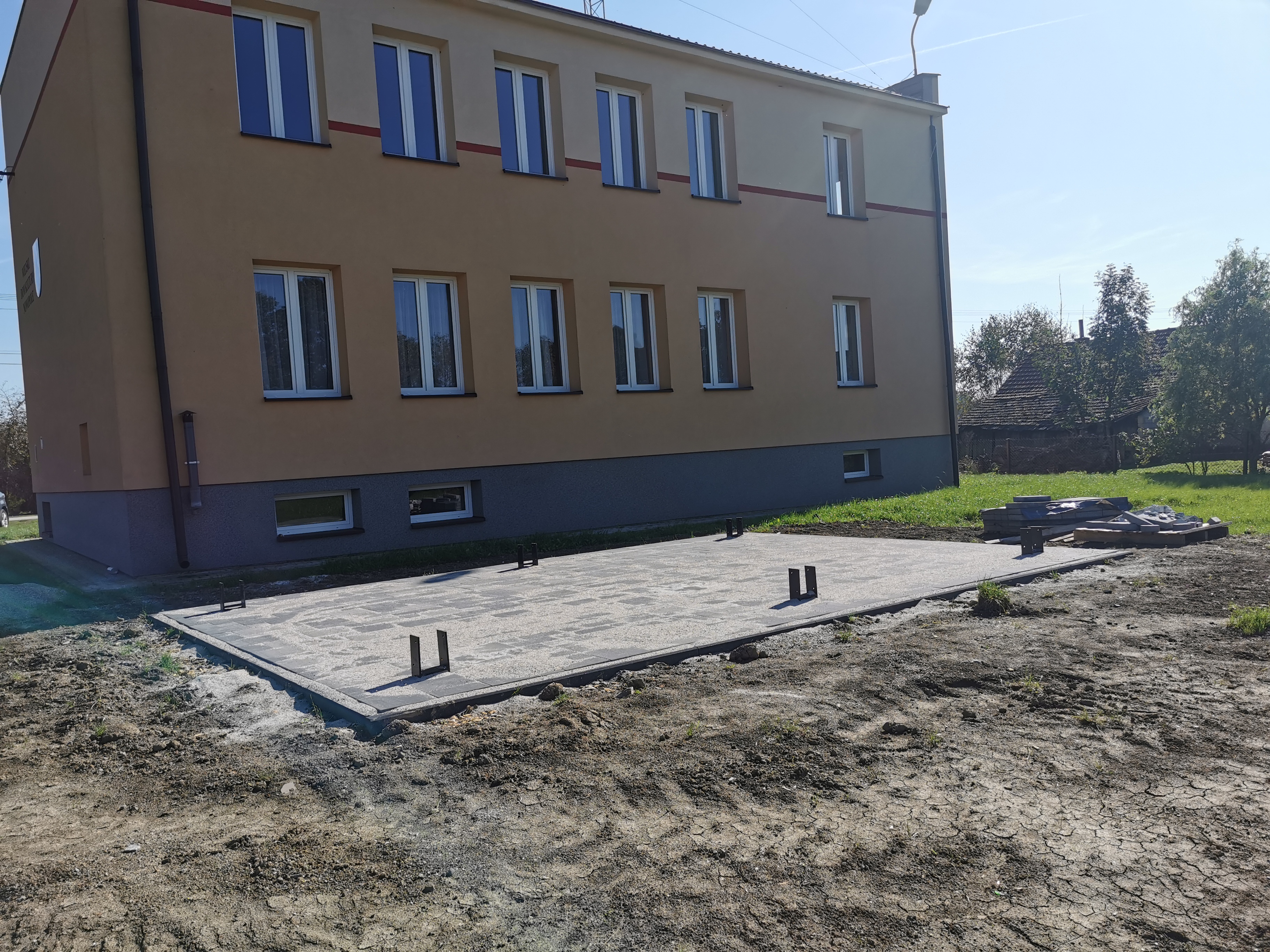 Budynek Domu Ludowego w Nowpolu oraz zarys fundamentu z kostki brukowej pod budowę wiaty.