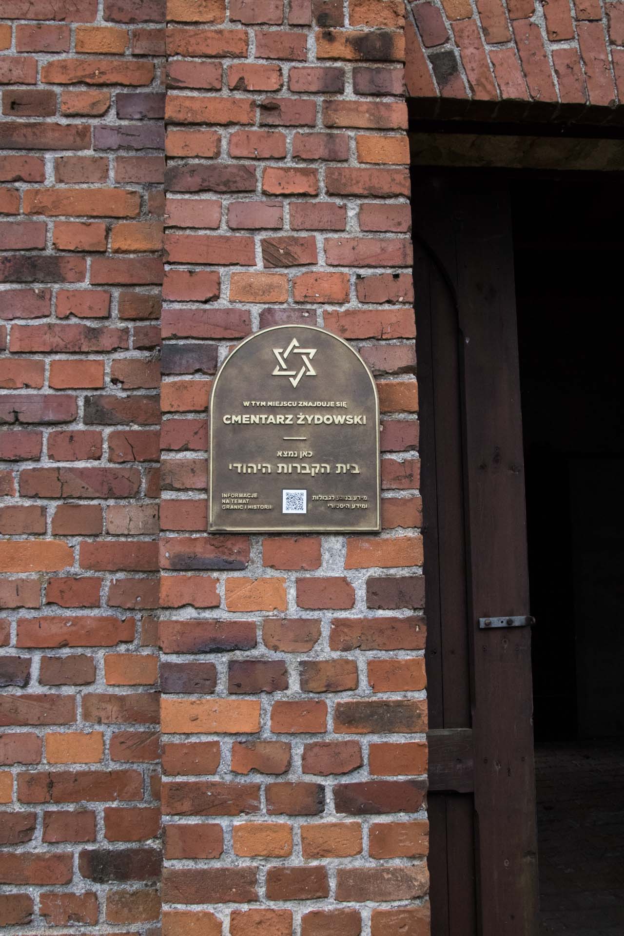 Nowoczesna tablica informacyjna na cmentarzu żydowskim w Oleśnie