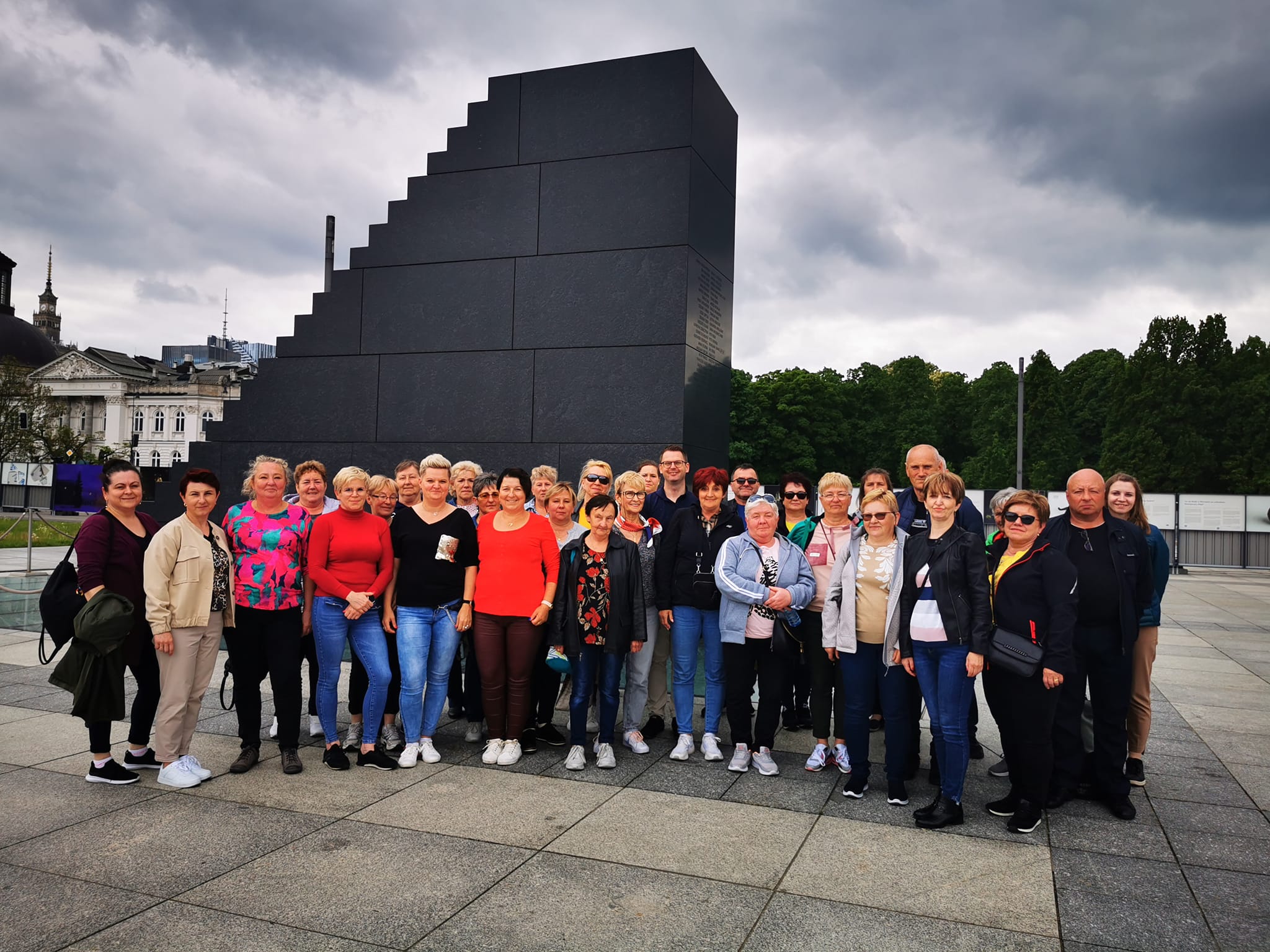 Zdjęcie przedstawia Koła Gospodyń Wiejskich oraz Wójta Gminy Wietrzychowice przed Pomnikiem Ofiar Smoleńskich w Warszawie