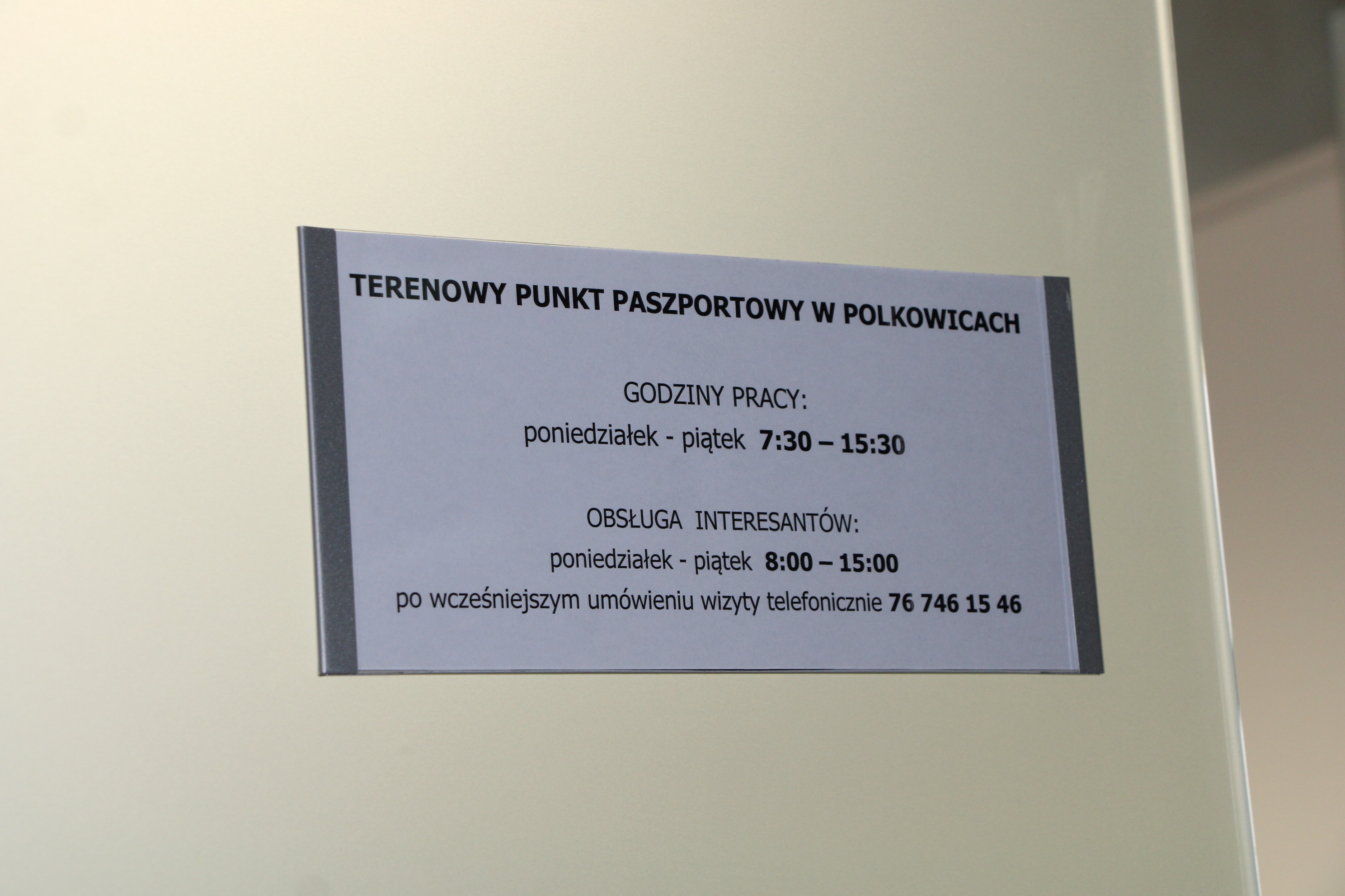 Tablica pokazuje godziny pracy punktu paszportowego w Polkowicach